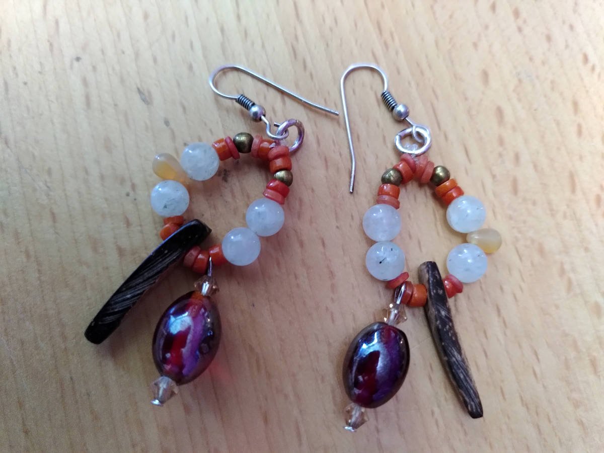 Paire de boucles d'oreille, en miroir ; dans chacune, il y un triangle de bois, une grosse perle pourpre entour&eacute;e de cristaux saumon, de petites perles rondes blanches, une goutte orange, de toutes petites perles de corail et deux perles rondes dor&eacute;es