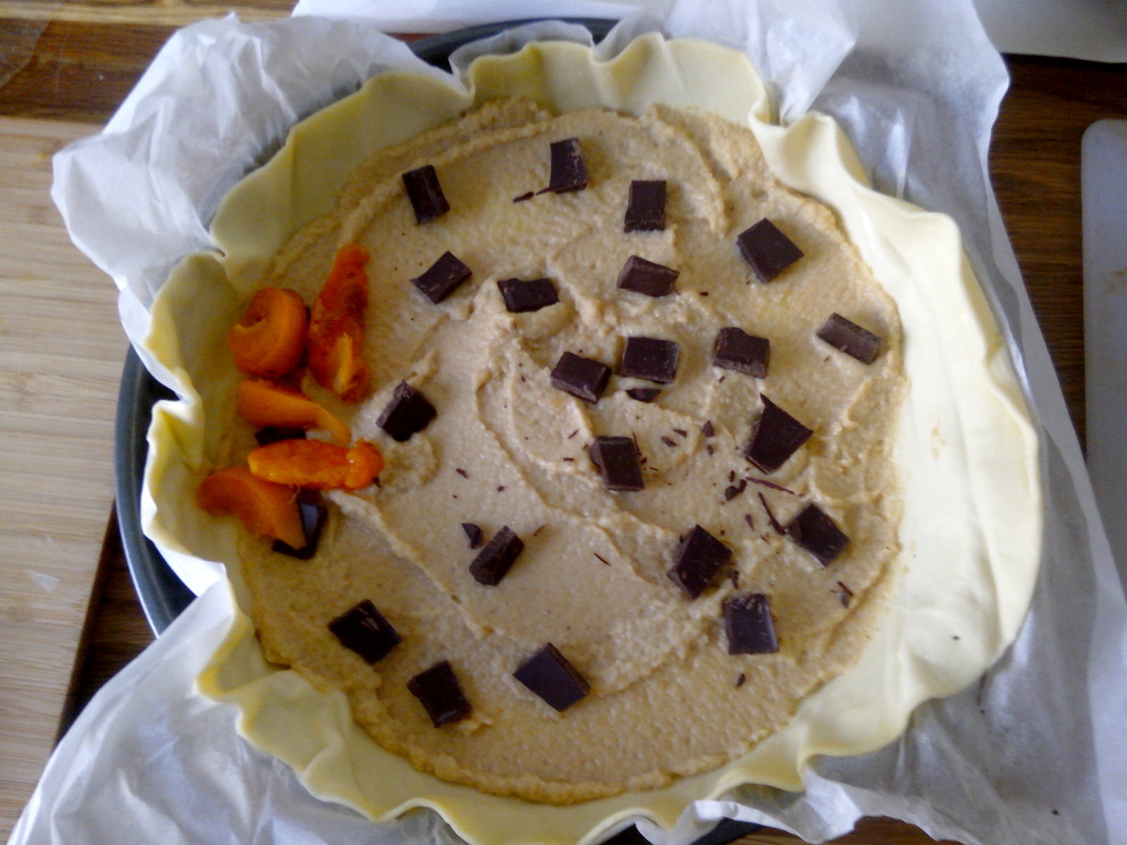Fond de tarte garni de l'appareil compote et beurre de cacahu&egrave;tes, de chocolat, et de quelques lunes d'abricot